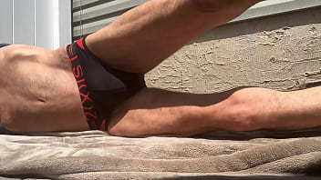 Stop Action Core Stretching on Patio in Black and Red Briefs