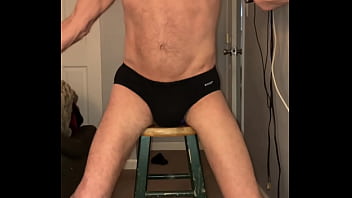 Pelvic Stretching on Stool with purple balls and Black briefs and socks